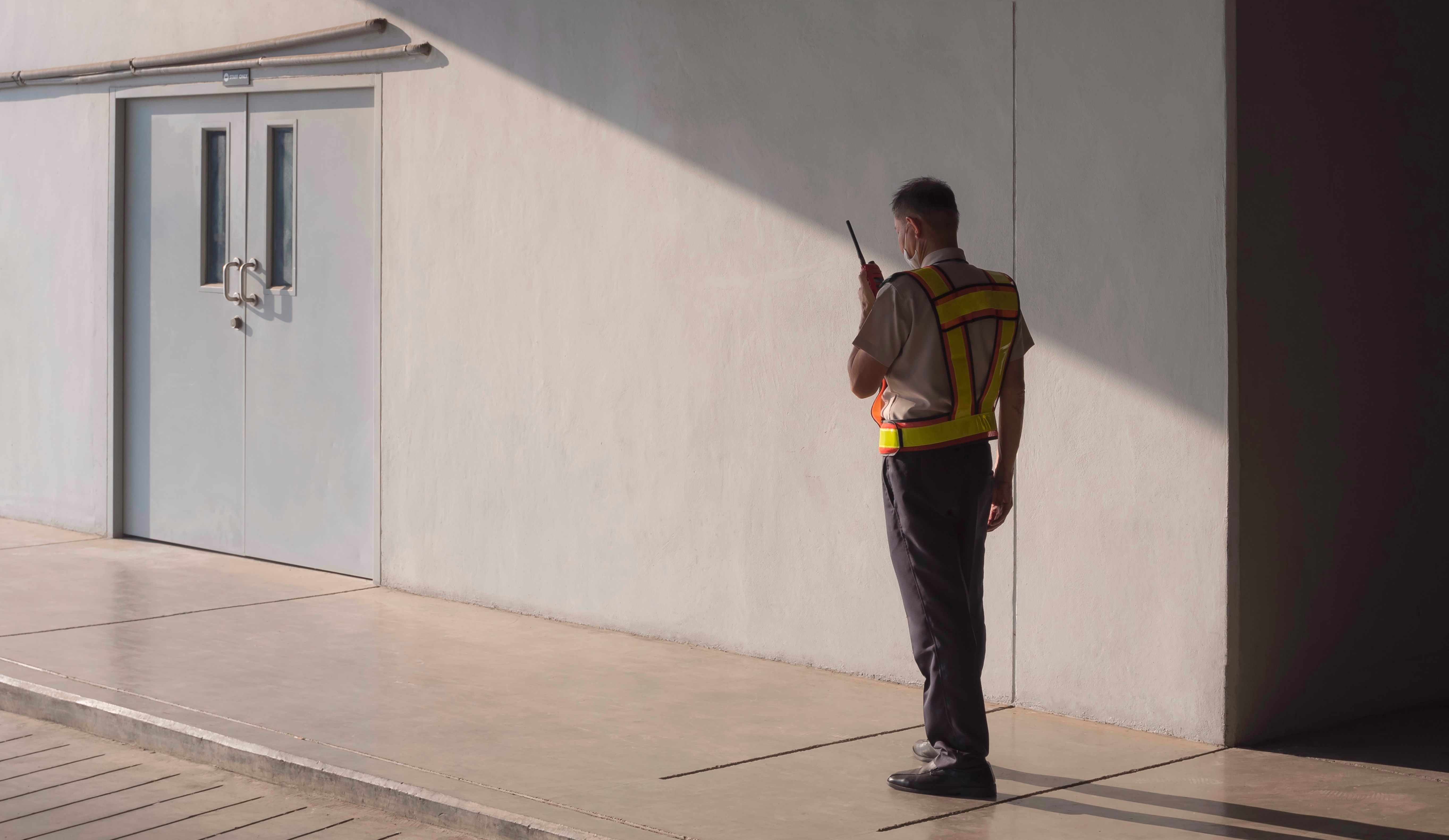 Security guard using walkie talkie while working in parking garage